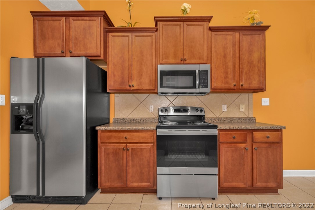 3540 Talus Road Fayetteville, NC 28306 - Photo 9 of 28 a kitchen with granite countertop a refrigerator stove and microwave