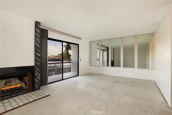a view of an empty room with a fireplace and a window