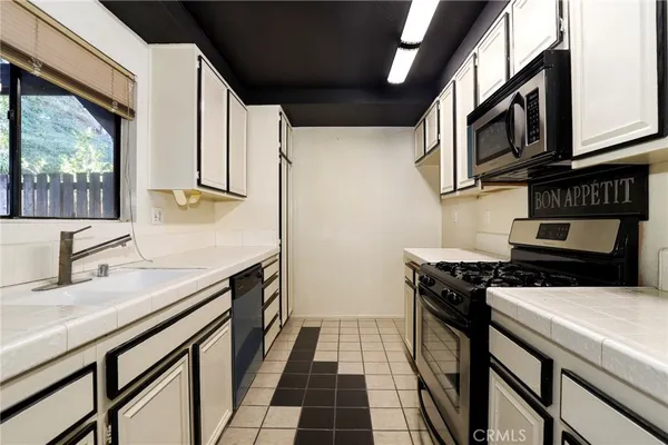 a kitchen with stainless steel appliances a stove a sink and a microwave