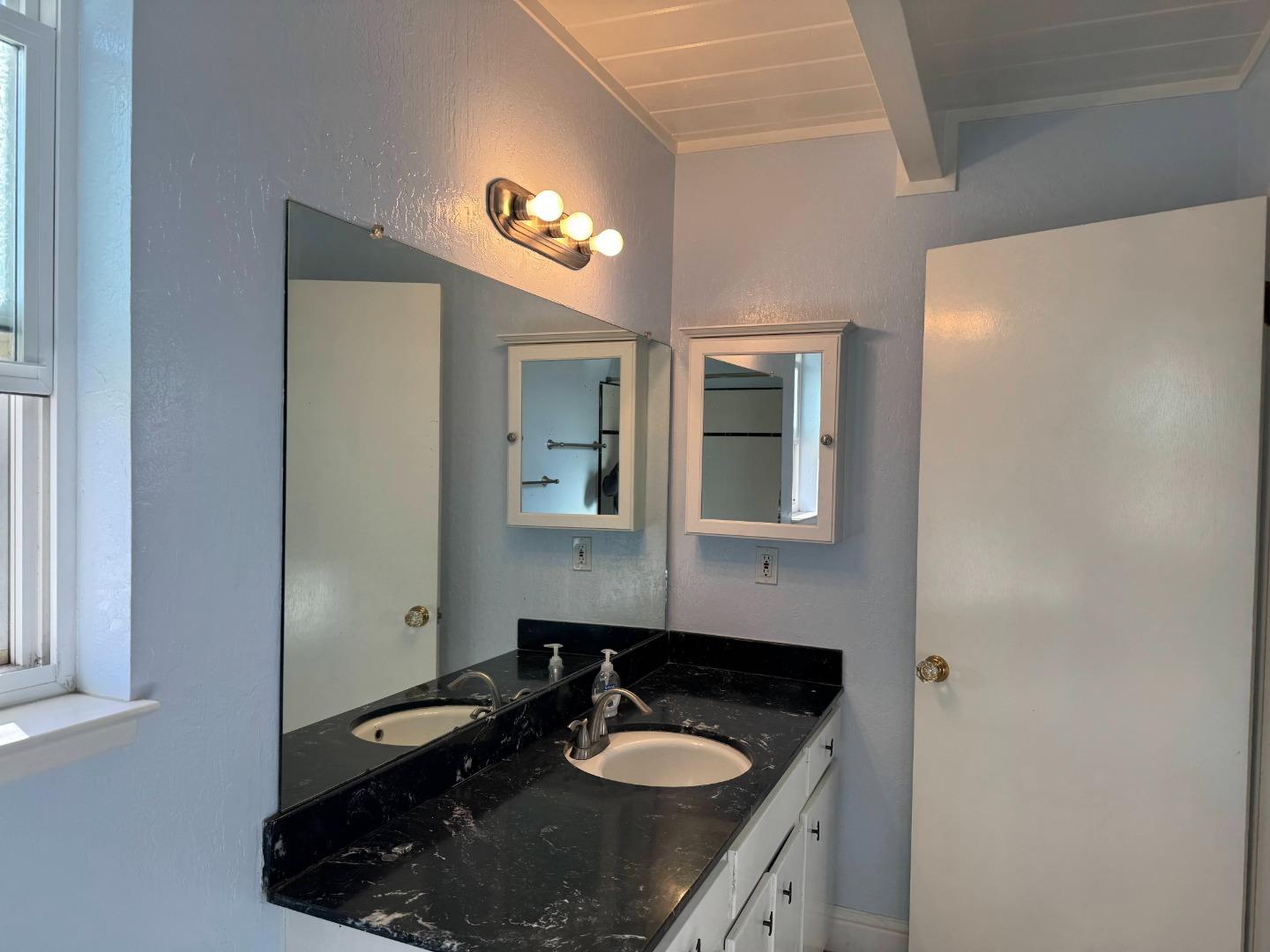 106 Winfield Way Aptos, CA 95003 - Photo 43 of 47 a bathroom with a granite countertop sink a mirror and a shower