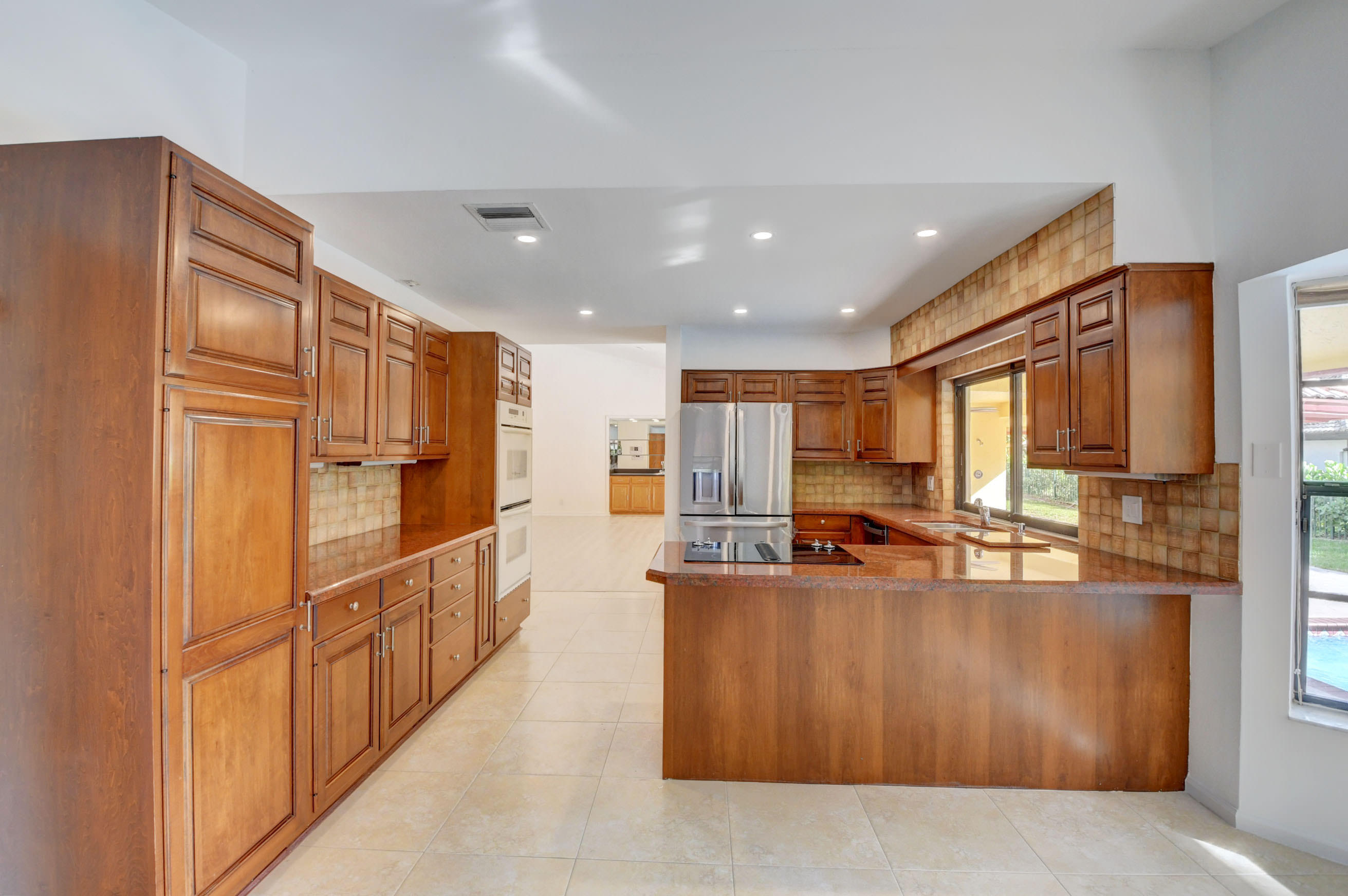 3230 St James Drive Boca Raton, FL 33434 - Photo 15 of 62 a large kitchen with stainless steel appliances granite countertop a refrigerator and a stove
