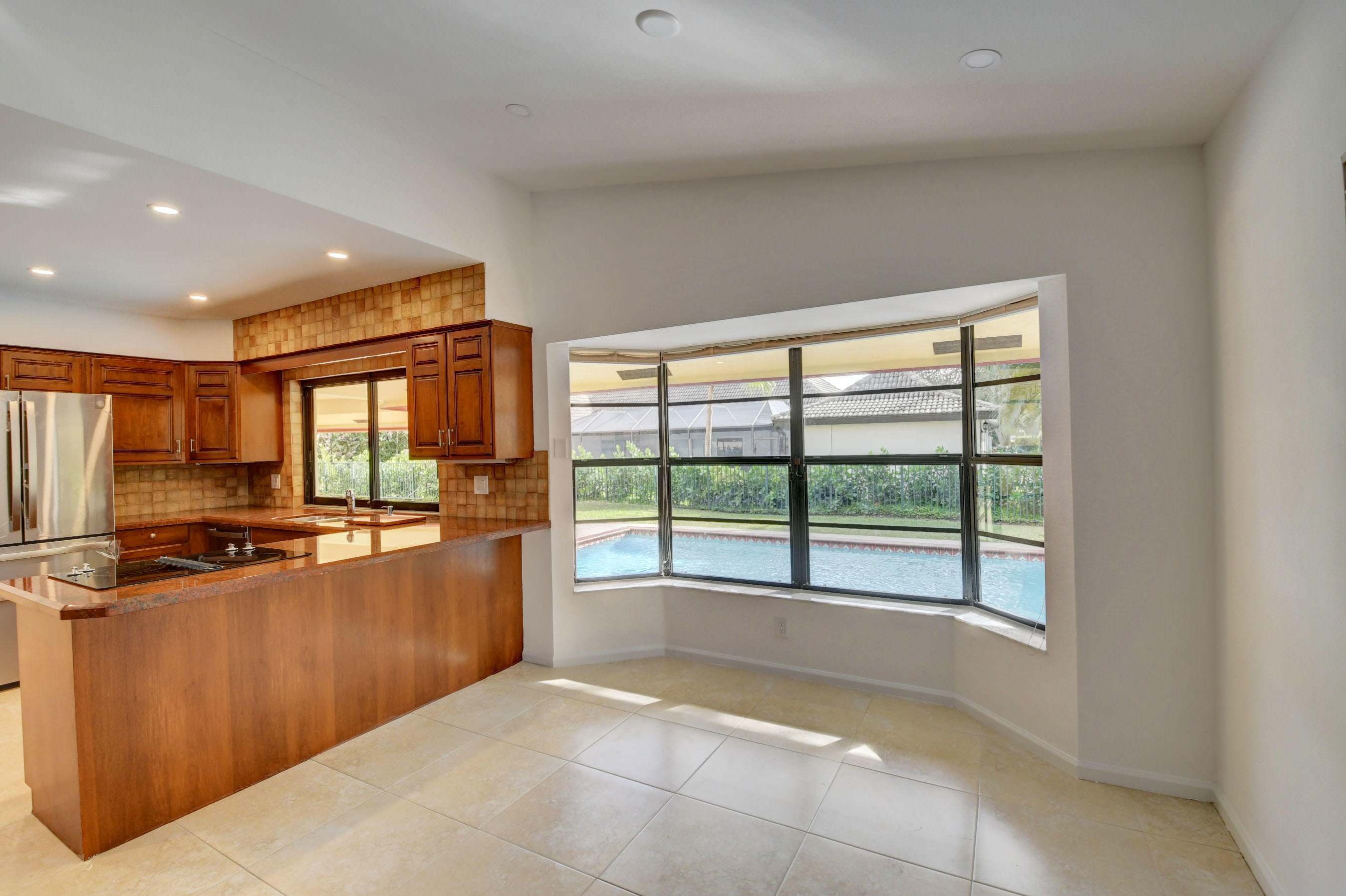 3230 St James Drive Boca Raton, FL 33434 - Photo 16 of 62 a view of a kitchen with stainless steel appliances granite countertop a large window and a sink
