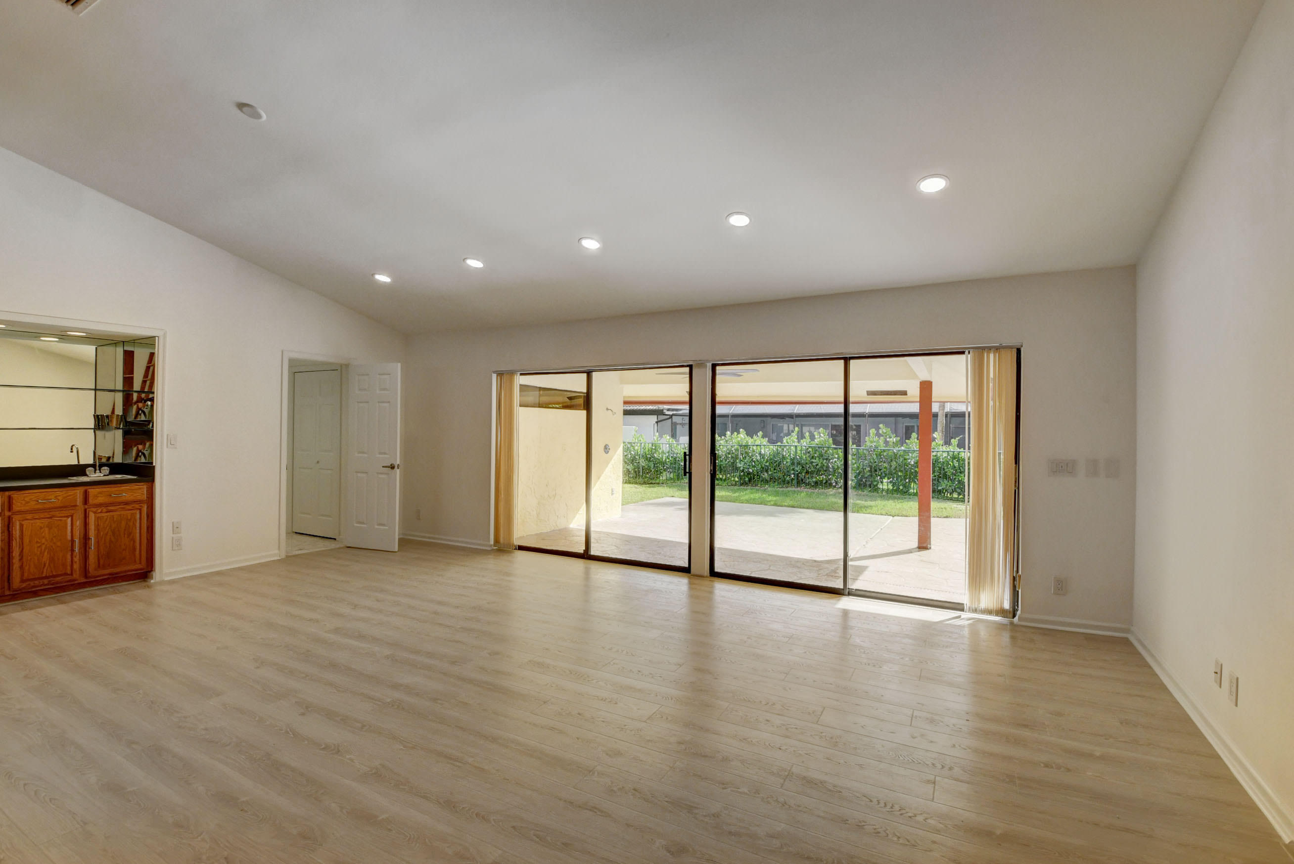 3230 St James Drive Boca Raton, FL 33434 - Photo 18 of 62 a view of empty room with wooden floor and floor to ceiling window