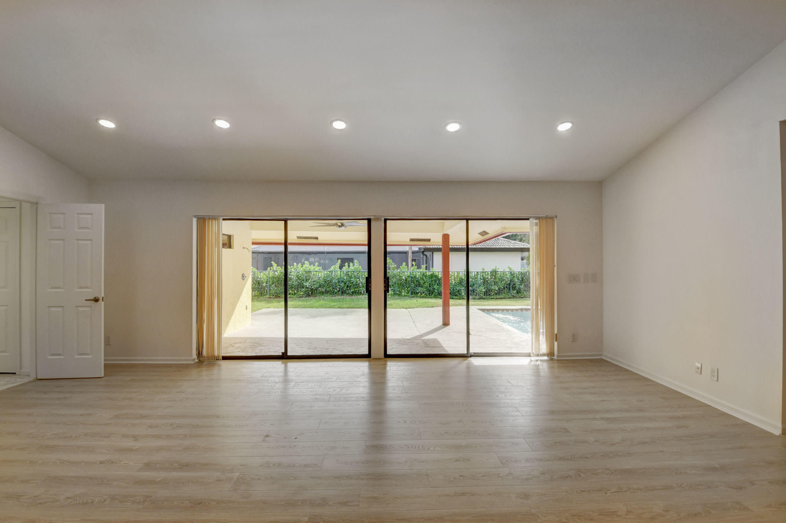 3230 St James Drive Boca Raton, FL 33434 - Photo 19 of 62 a view of empty room with wooden floor and floor to ceiling window