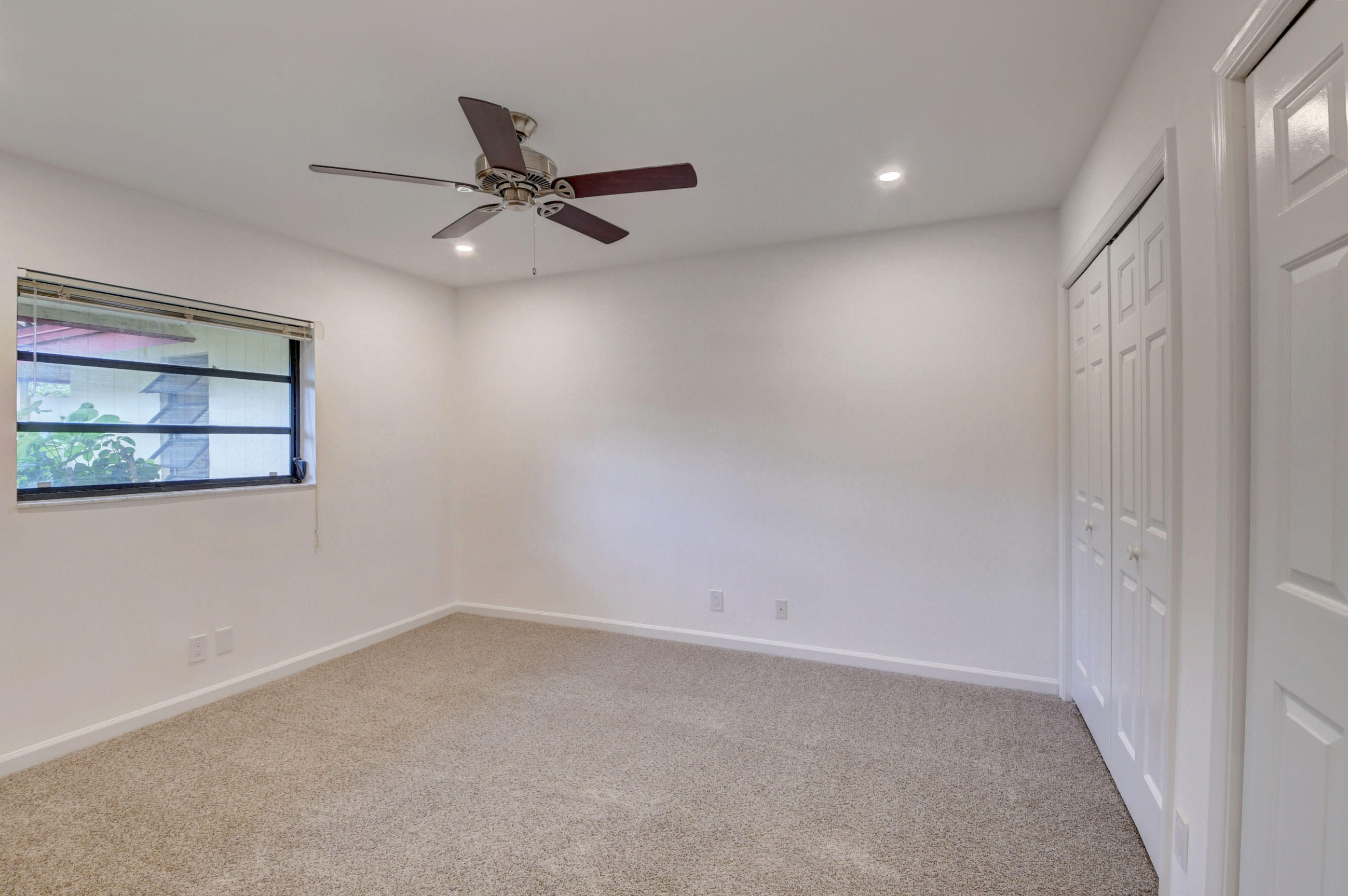 3230 St James Drive Boca Raton, FL 33434 - Photo 38 of 62 an empty room with a ceiling fan and window