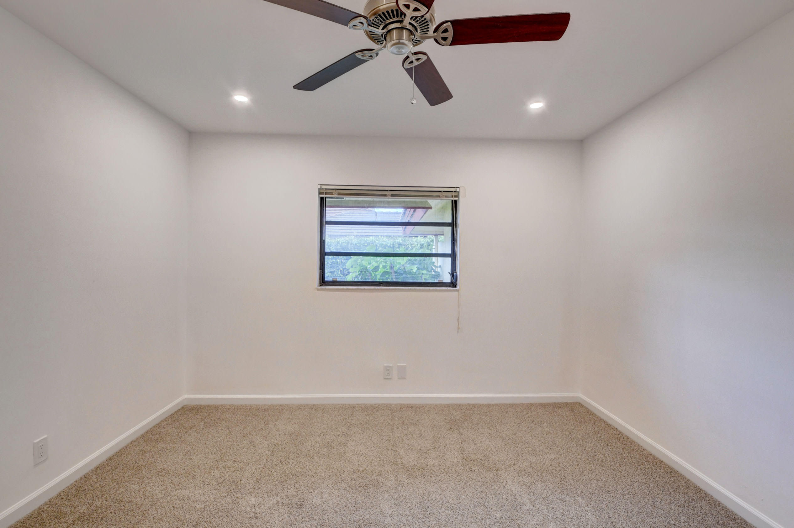 3230 St James Drive Boca Raton, FL 33434 - Photo 39 of 62 an empty room with window and ceiling fan