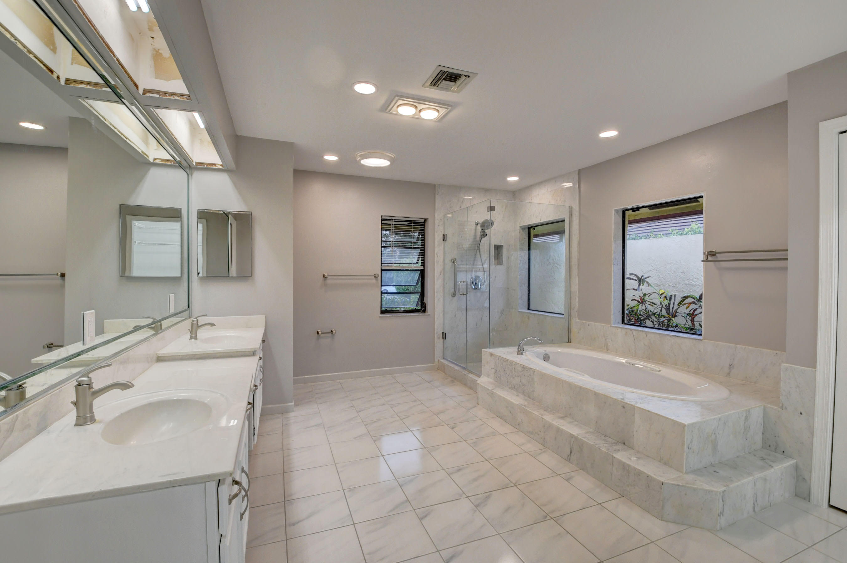 3230 St James Drive Boca Raton, FL 33434 - Photo 49 of 62 a spacious bathroom with a tub sink and mirror