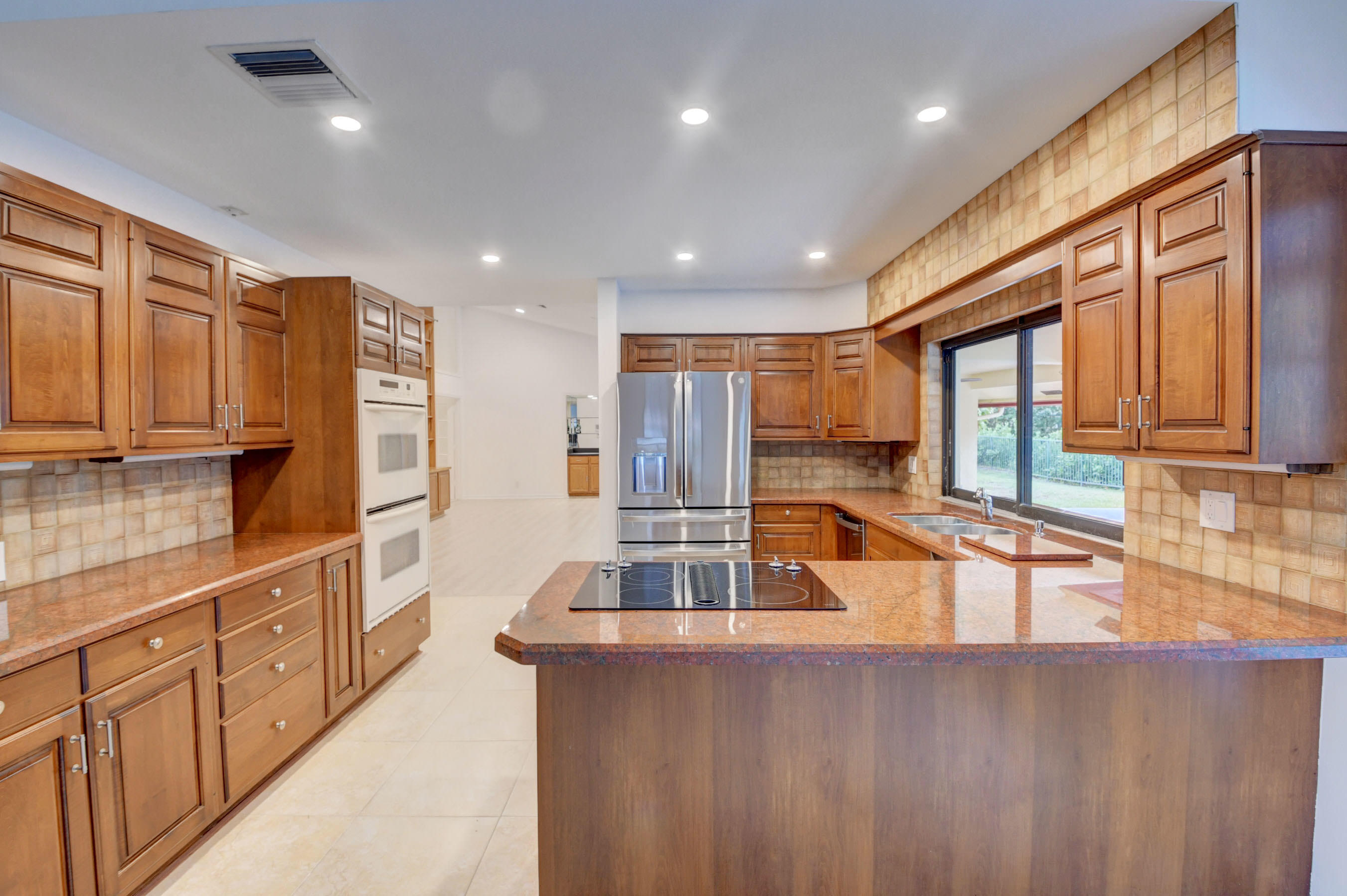 3230 St James Drive Boca Raton, FL 33434 - Photo 58 of 62 a kitchen with stainless steel appliances granite countertop a refrigerator and a sink