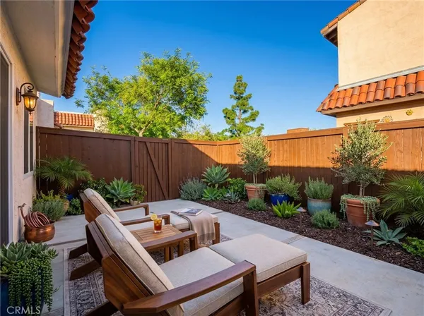a backyard of a house with a garden and outdoor seating