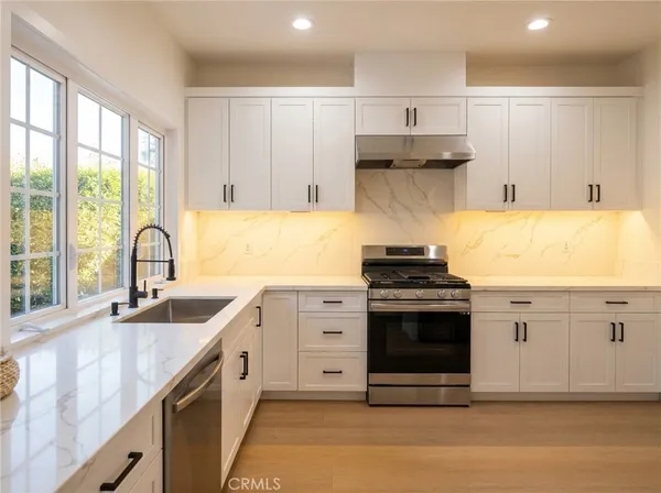 a kitchen with stainless steel appliances granite countertop a sink stove and cabinets