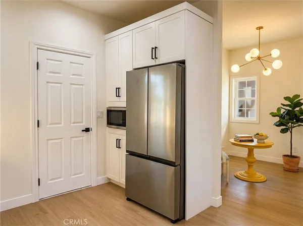 a kitchen with stainless steel appliances granite countertop a refrigerator a stove and a wooden floors