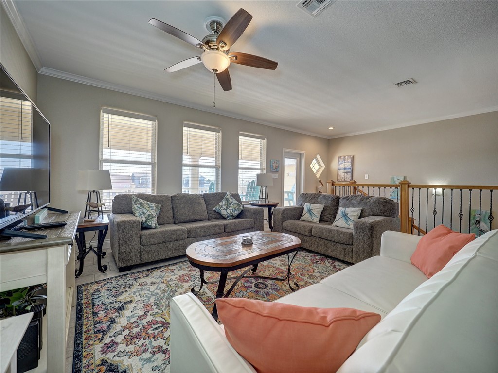 1833 Eleventh Street, Unit F2 Port Aransas, TX 78373 - Photo 12 of 40 a living room with furniture a chandelier and a rug