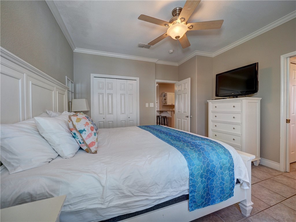 1833 Eleventh Street, Unit F2 Port Aransas, TX 78373 - Photo 18 of 40 a bedroom with a bed and a flat screen tv