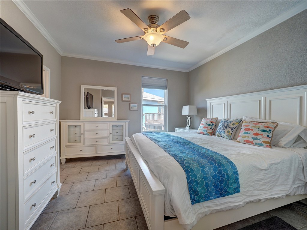 1833 Eleventh Street, Unit F2 Port Aransas, TX 78373 - Photo 19 of 40 a spacious bedroom with a bed and a flat screen tv