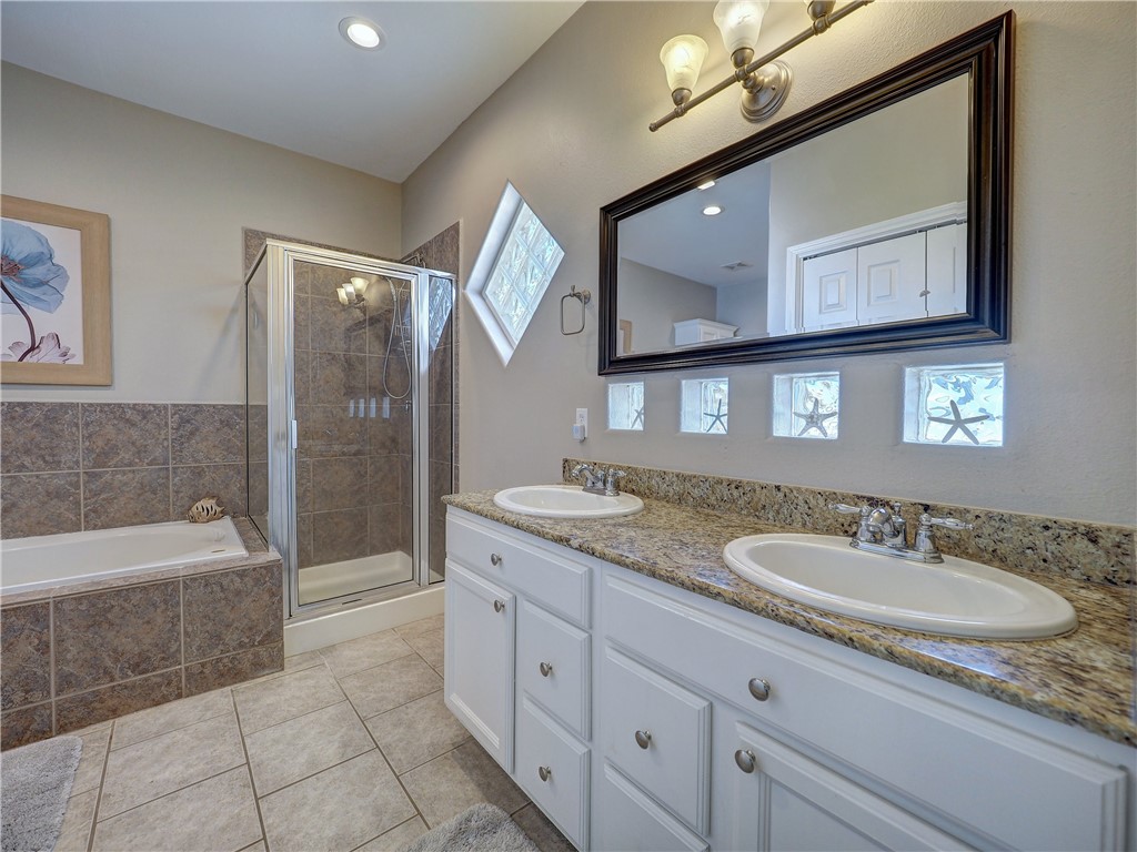 1833 Eleventh Street, Unit F2 Port Aransas, TX 78373 - Photo 20 of 40 a spacious bathroom with a granite countertop tub sink and mirror
