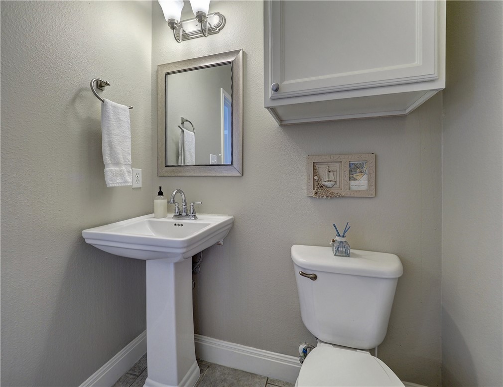 1833 Eleventh Street, Unit F2 Port Aransas, TX 78373 - Photo 27 of 40 a bathroom with a toilet sink and mirror
