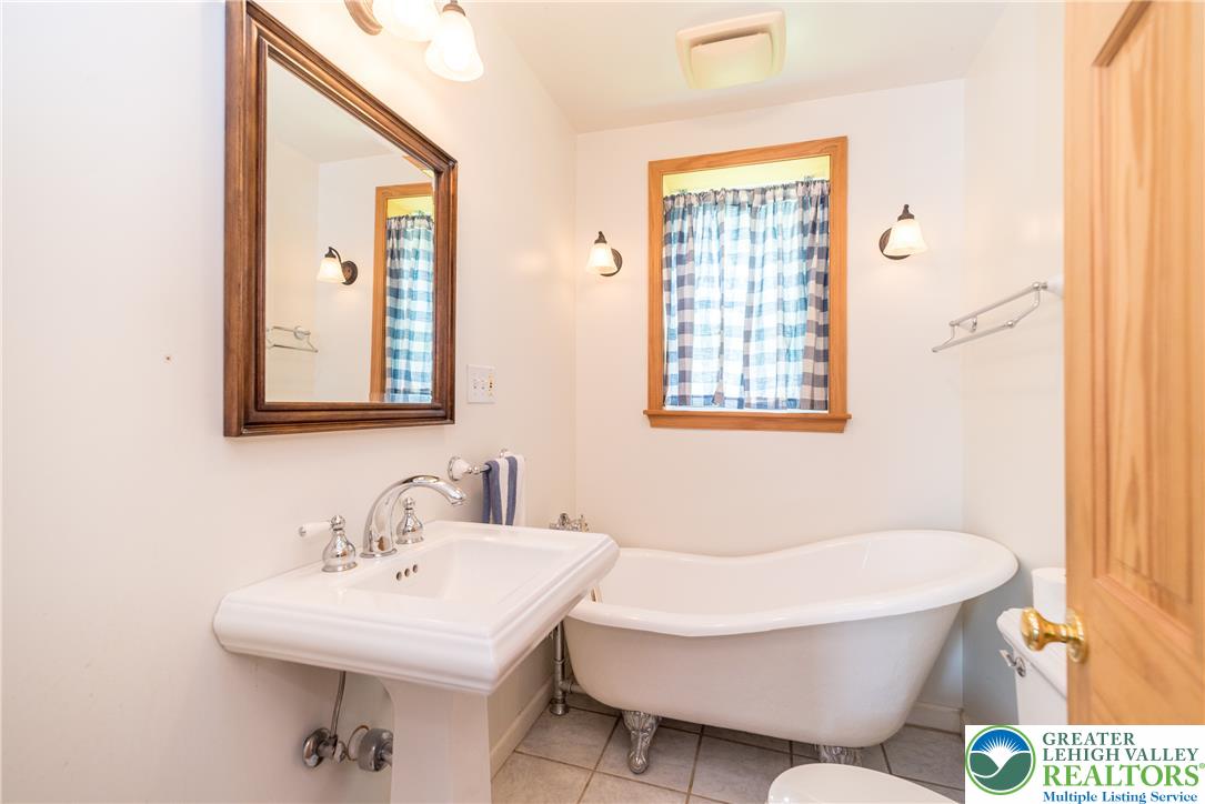 1815 Leithsville Road Hellertown, PA 18055 - Photo 7 of 38 A pristine pedestal sink and a classic claw-foot tub define this bright, functional bathroom.