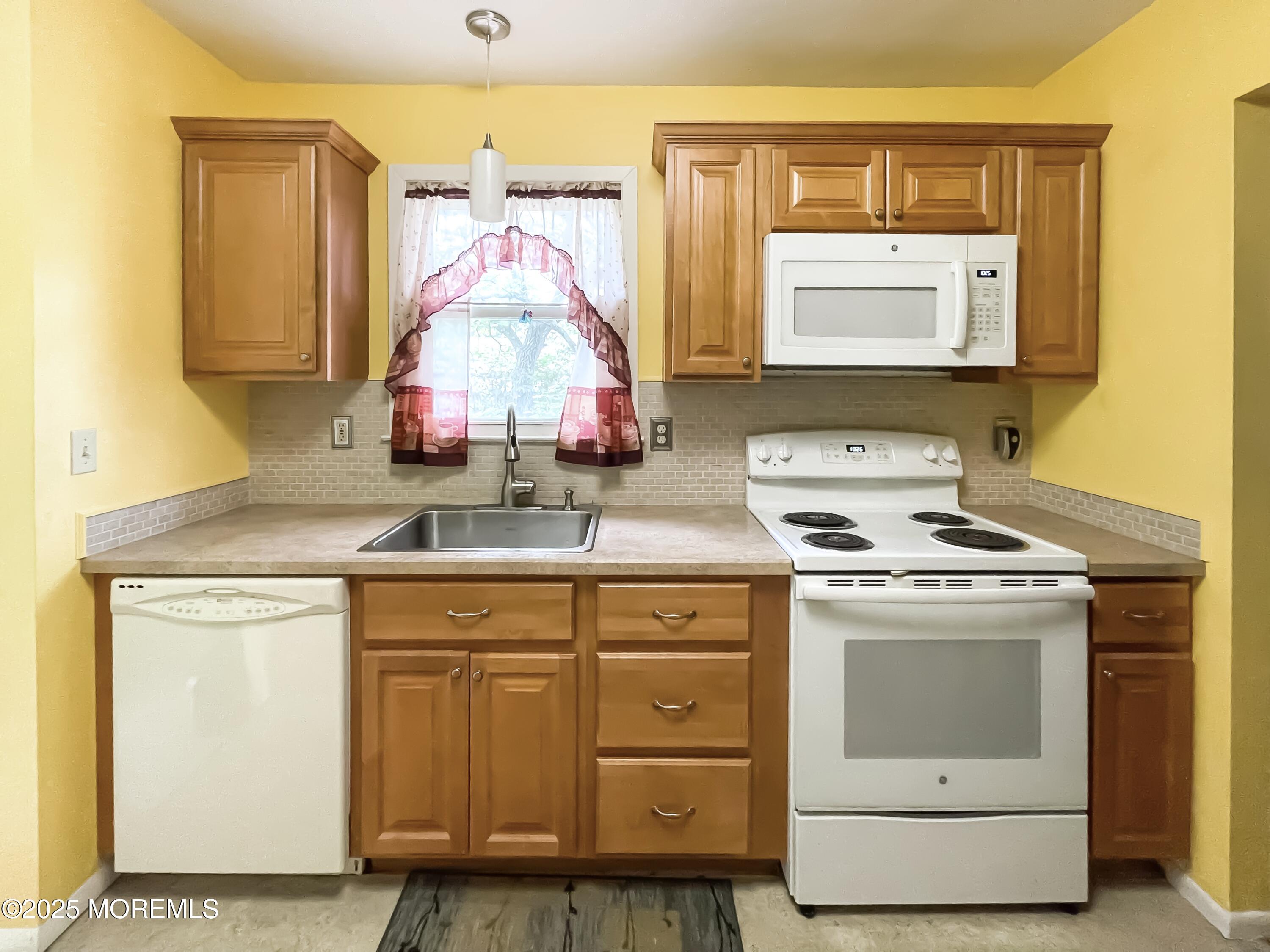 4 Churchill Road, Unit 71 Manchester Township, NJ 08759 - Photo 3 of 12 a kitchen with sink a stove and white cabinets