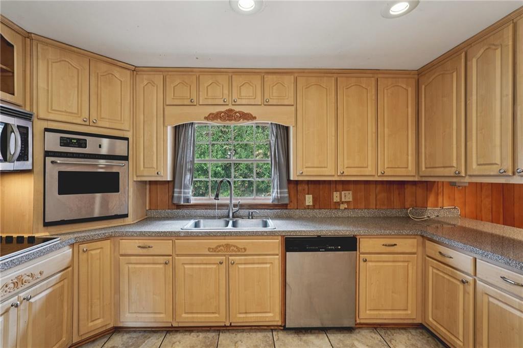 3407 West Manor Lane Southwest Atlanta, GA 30311 - Photo 11 of 36 a kitchen with stainless steel appliances granite countertop a stove a sink and a microwave