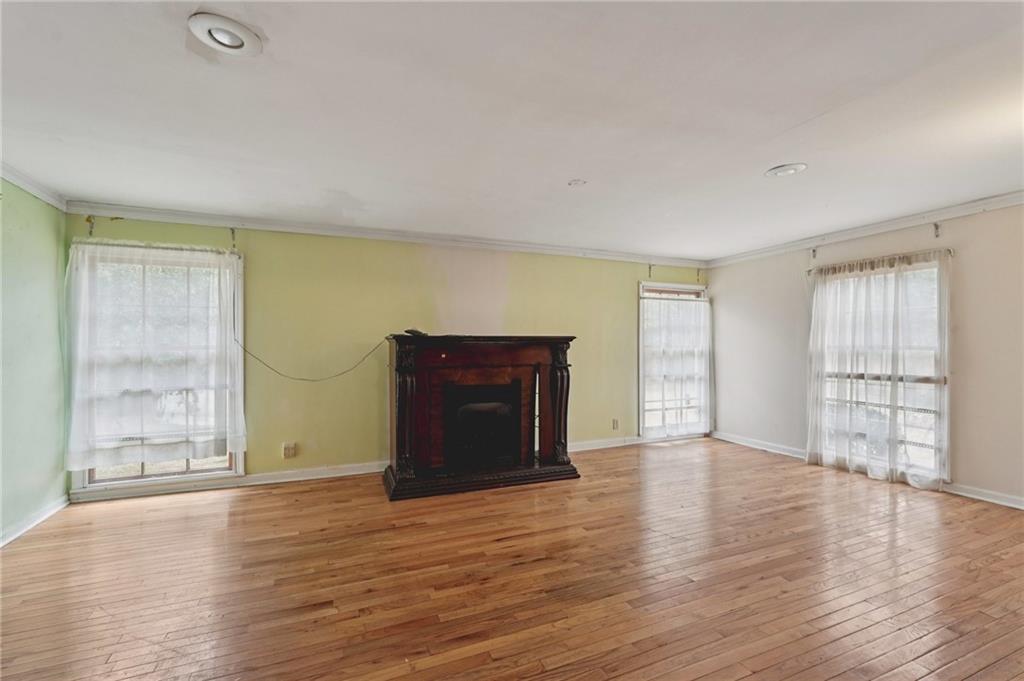 3407 West Manor Lane Southwest Atlanta, GA 30311 - Photo 18 of 36 an empty room with wooden floor and windows