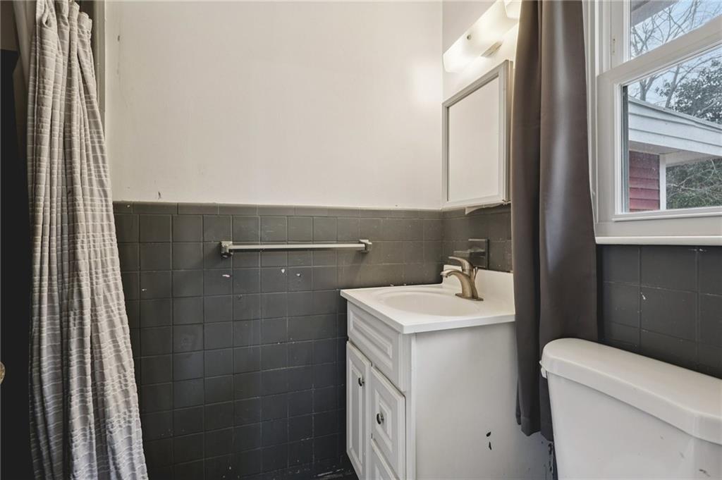 3407 West Manor Lane Southwest Atlanta, GA 30311 - Photo 33 of 36 a bathroom with a sink toilet and mirror