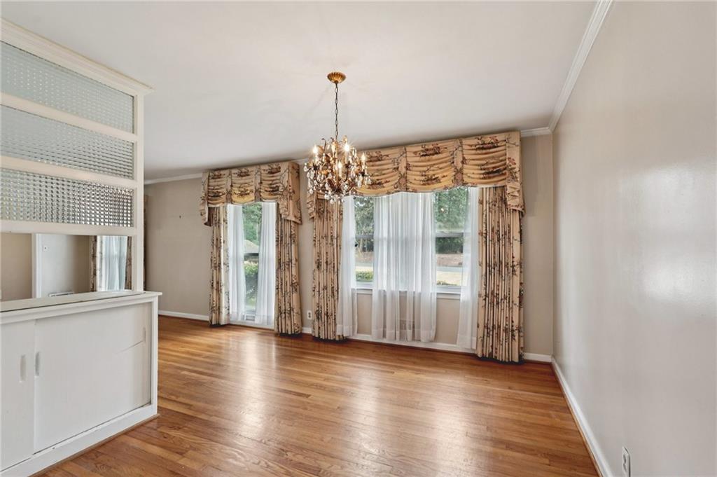 3407 West Manor Lane Southwest Atlanta, GA 30311 - Photo 4 of 36 an empty room with wooden floor and windows