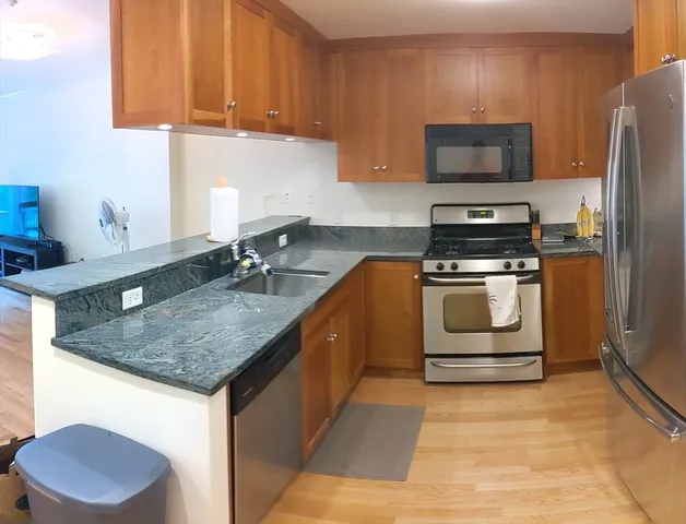a kitchen with stainless steel appliances granite countertop a sink stove and refrigerator