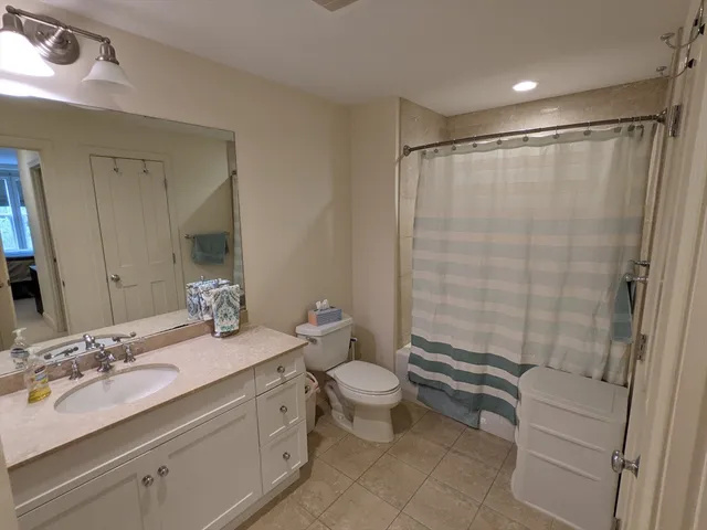 a bathroom with a double vanity sink toilet and shower