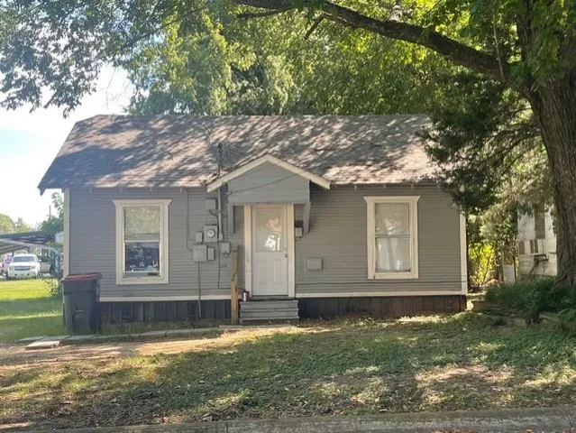 a view of a house with a big yard and large tree
