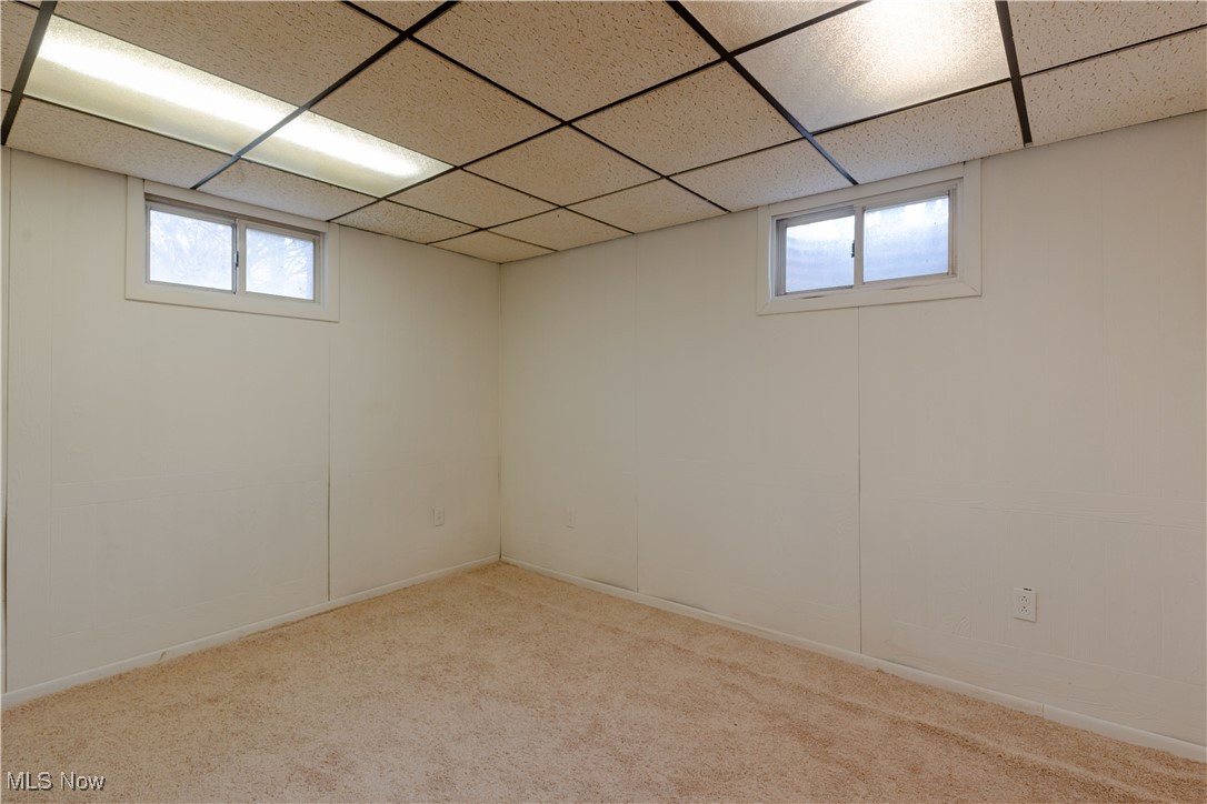 1639 South Ridge Road West Ashtabula, OH 44004 - Photo 37 of 44 Below grade area with carpet floors, a drop ceiling, and plenty of natural light