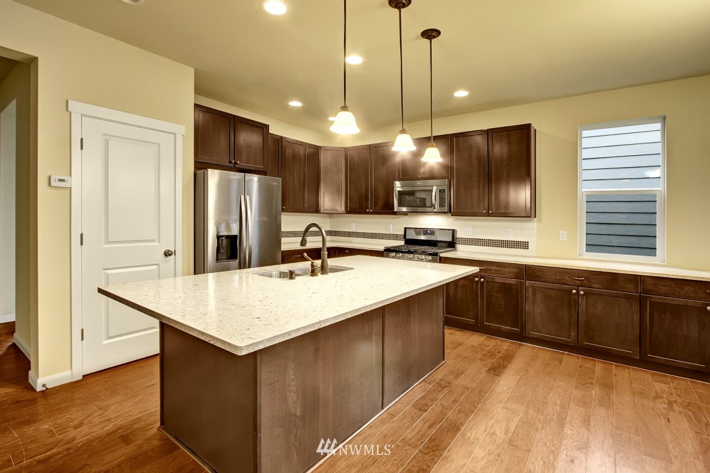 3609 177th Place Southeast, Unit 1015 Bothell, WA 98012 - Photo 2 of 14 a kitchen with kitchen island a sink appliances and a counter top space