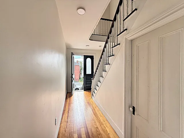 a view of staircase with lots of frames on wall and wooden floor