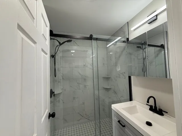 a bathroom with a shower sink and mirror
