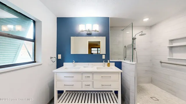 an empty room with wooden floor chandelier fan and windows
