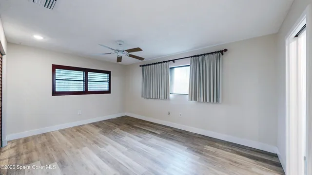a view of a room with wooden floor and a large window