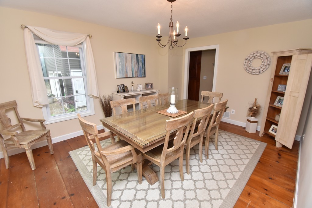 286 Main Road Montgomery, MA 01085 - Photo 8 of 27 a dining room with wooden floor a chandelier a wooden table and chairs
