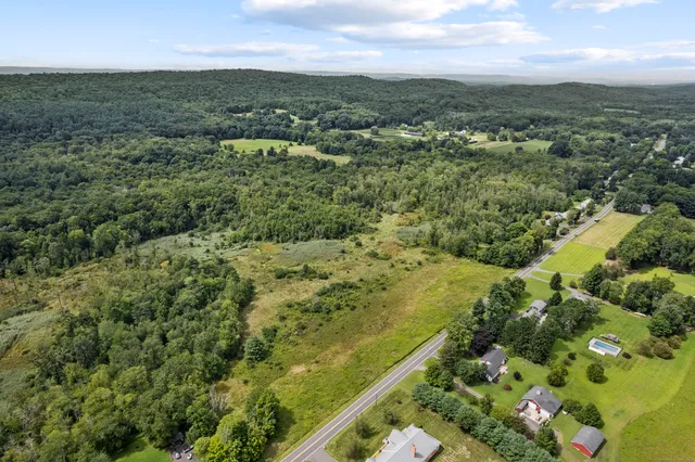an aerial view of residential houses with outdoor space and trees
