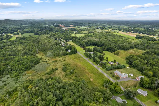 an aerial view of residential houses with outdoor space and trees