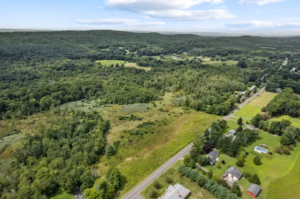 an aerial view of residential houses with outdoor space and trees