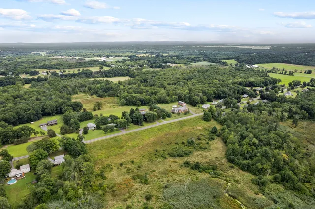 an aerial view of residential houses with outdoor space and trees