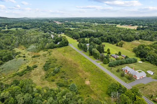 an aerial view of residential houses with outdoor space and trees