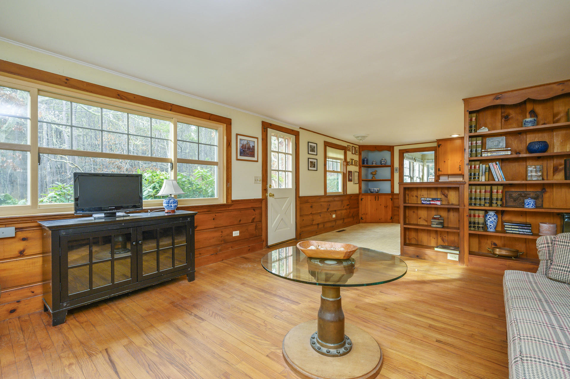 289 Cahoon Hollow Road Wellfleet, MA 02667 - Photo 6 of 25 a living room with furniture a flat screen tv and a floor to ceiling window