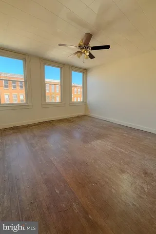 an empty room with a ceiling fan and carpet