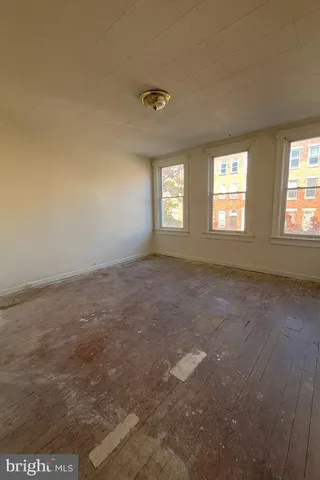 an empty room with a ceiling fan and a window