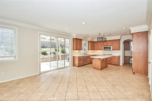 a large kitchen with stainless steel appliances kitchen island granite countertop a large counter top and a view of living room