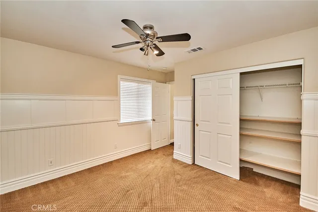 a view of an empty room with a ceiling fan