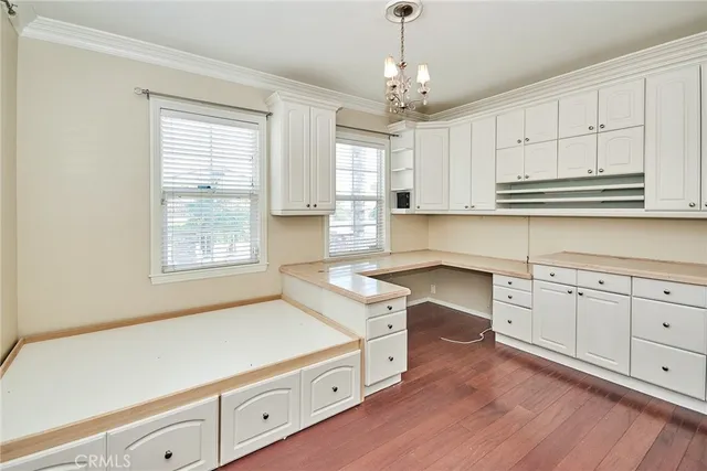 a kitchen with stainless steel appliances granite countertop a sink dishwasher a stove and white cabinets with wooden floor