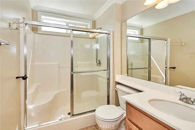 a bathroom with a shower sink vanity mirror and toilet