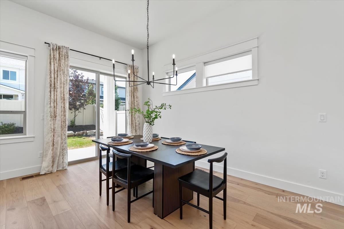 11379 West Helenium Drive Star, ID 83669 - Photo 11 of 50 Dining room featuring light wood-style flooring and a chandelier