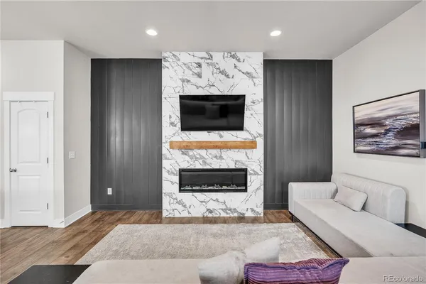 a living room with furniture a flat screen tv and a fireplace